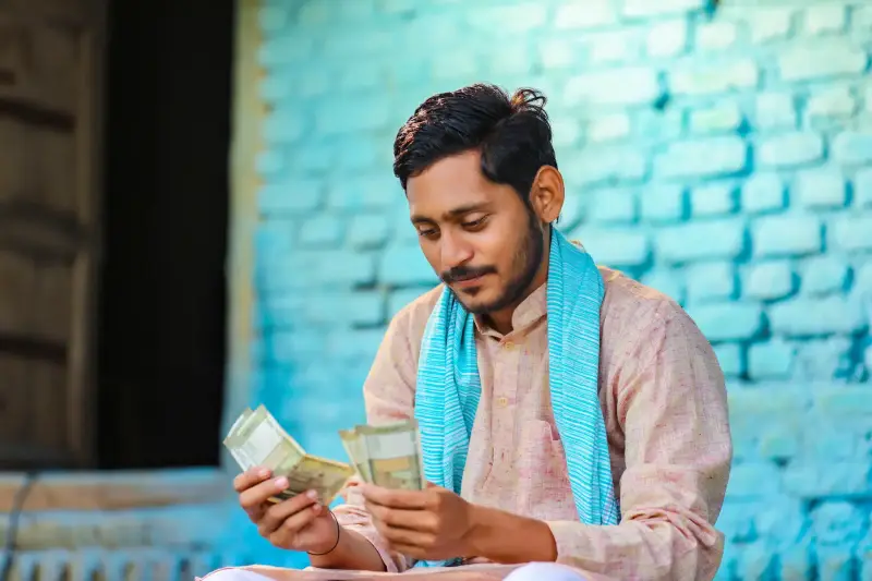 Small business owner counting earnings at home in India