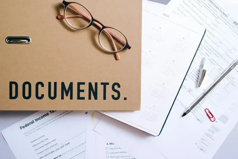 Documents folder with glasses and financial papers