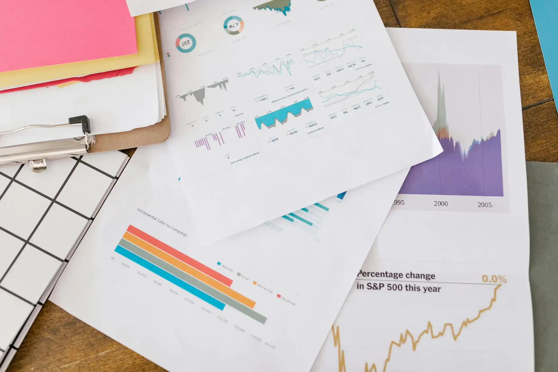 Financial performance charts and reports spread on a desk