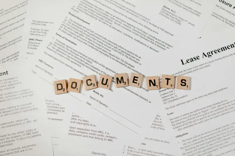 Documents text spelled with letter tiles on contract papers